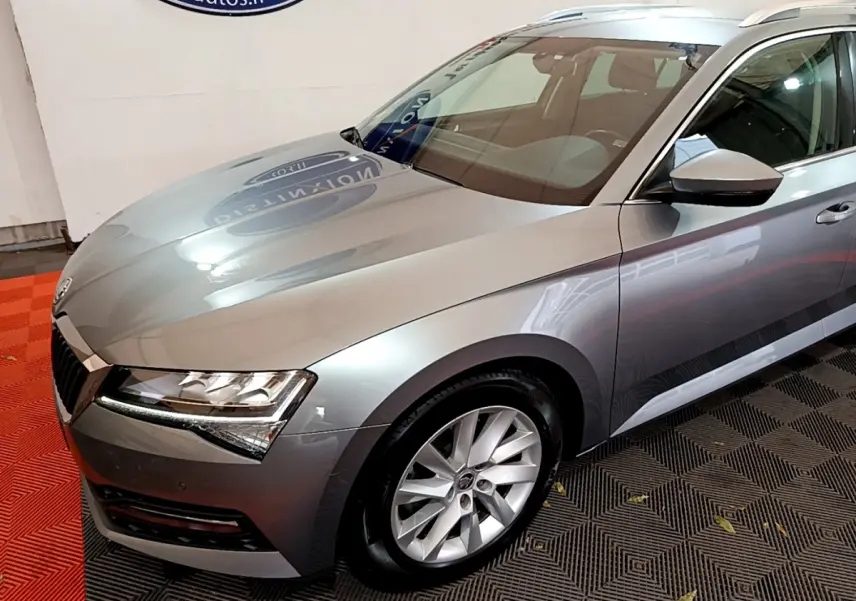 Vue 3/4 avant droit d'une Skoda Superb gris clair 2020 avec phares LED et jantes alliage visibles.