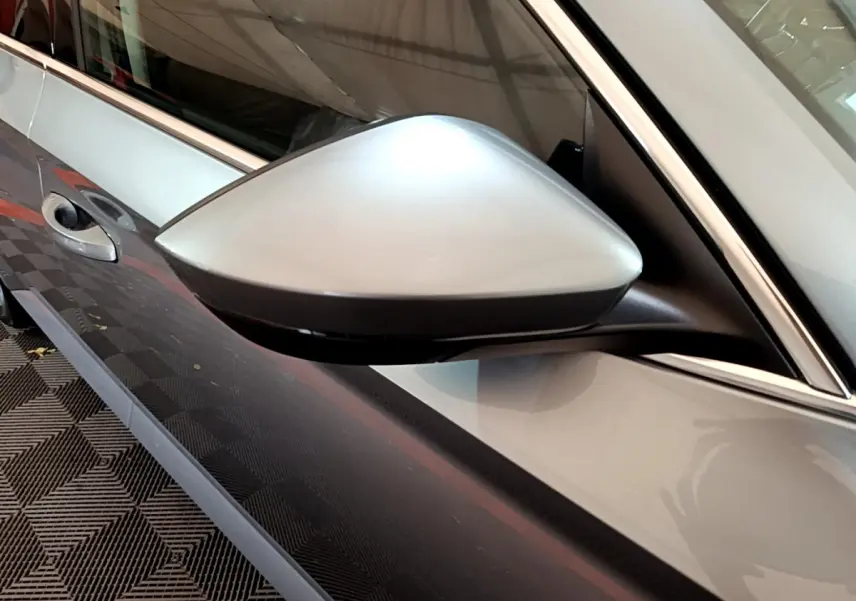 Rétroviseur côté gauche gris clair de la Skoda Superb 2020, avec poignée de porte et partie de la portière visible.