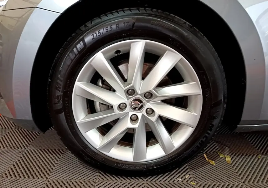 Gros plan sur la roue avant gauche gris clair de la Skoda Superb 2020 avec jante alliage et logo au centre