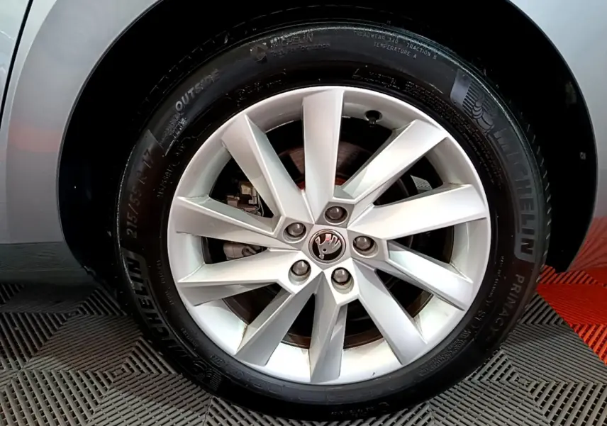 Gros plan sur la jante alliage argentée et pneu Michelin d'une Skoda Superb gris clair, côté droit.