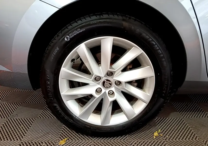 Gros plan sur la jante alliage argentée et pneu Michelin d'une Skoda Superb gris clair côté arrière.
