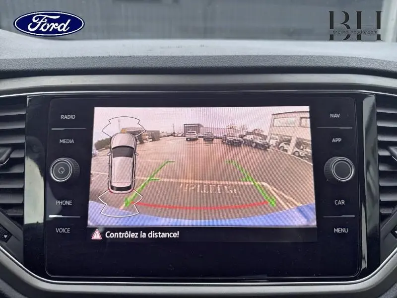 Écran de caméra de recul du Volkswagen T-Roc bleu Ravenna, vue arrière avec guidage de trajectoire verte et rouge.