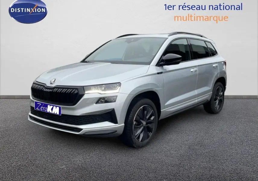 Vue 3/4 avant d’un Skoda Karoq gris argent métallisé avec jantes noires et calandre noire sportive.