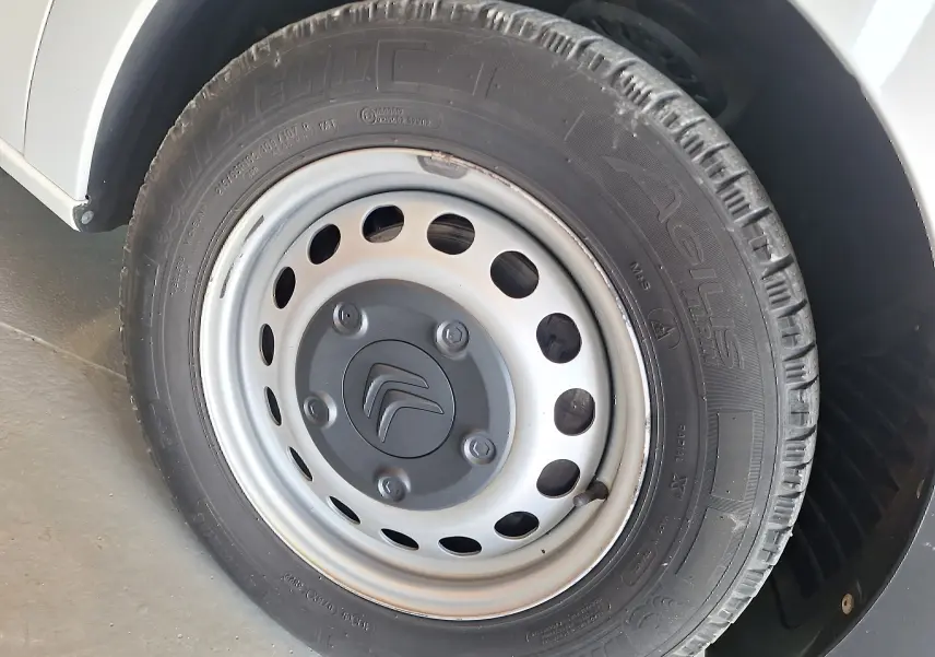 Gros plan sur la roue avant gauche blanche d'un Citroën Jumpy 2.0 BlueHDi 120 Club avec jante acier et logo Citroën.