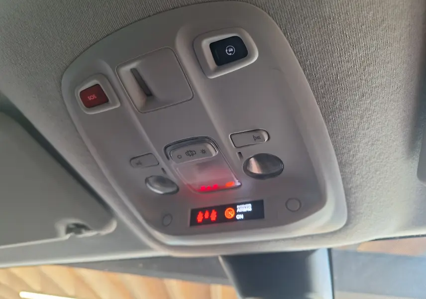 Vue en gros plan du plafonnier intérieur gris clair du Citroën Jumpy blanc, avec boutons SOS et éclairage.