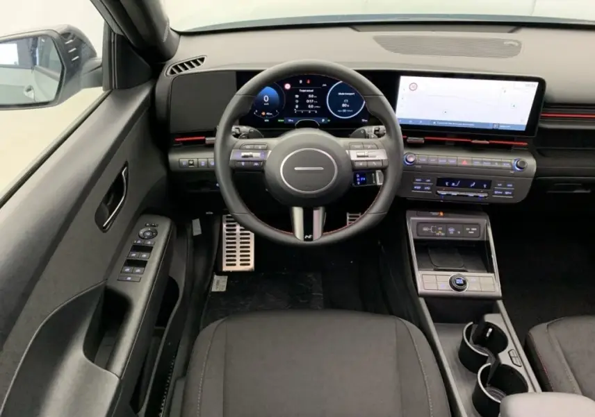 Vue intérieure frontale du tableau de bord du Hyundai Kona Hybrid 2025, avec écran numérique et volant multifonction.