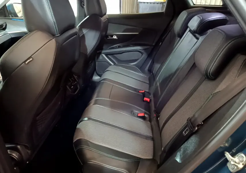 Vue intérieure côté droit des sièges arrière noirs en cuir et tissu du Peugeot 3008 hybride rechargeable bleu 2021.