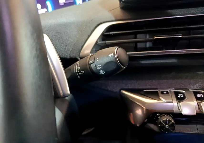 Gros plan sur la commande d’essuie-glace à gauche du volant dans l’habitacle bleu du Peugeot 3008 hybride rechargeable 2021.