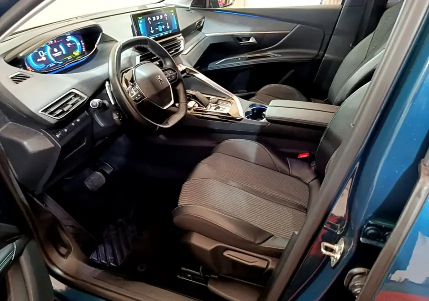 Intérieur côté conducteur bleu Peugeot 3008 Hybrid 2021, volant cuir, tableau de bord digital et sièges noirs.