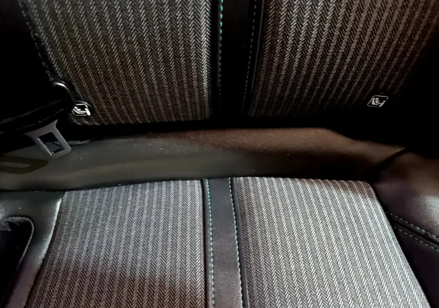 Gros plan sur la banquette arrière en tissu gris à motif chevrons du Peugeot 3008 hybride rechargeable.