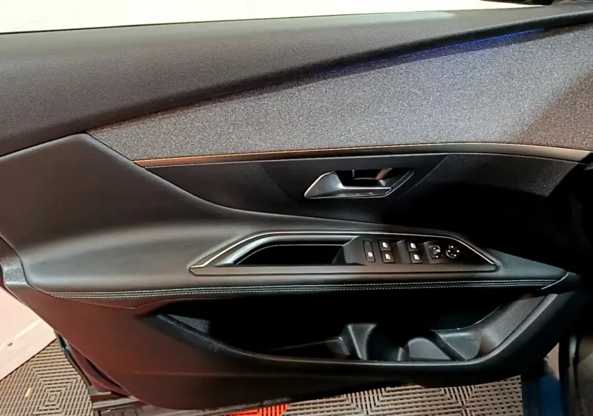 Intérieur côté gauche de la porte PEUGEOT 3008 bleu, avec commandes électriques et poignée argentée.