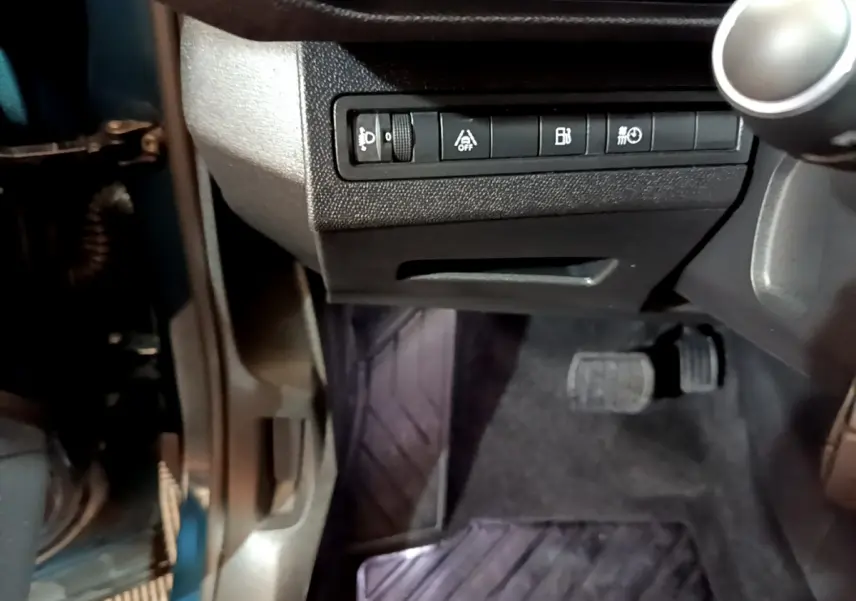 Vue rapprochée côté gauche sous le tableau de bord du Peugeot 3008 bleu, avec pédales et commandes visibles.