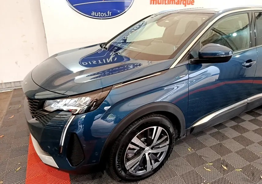 Vue 3/4 avant droit d'un Peugeot 3008 bleu hybride rechargeable avec phares LED et jantes alliage distinctives.