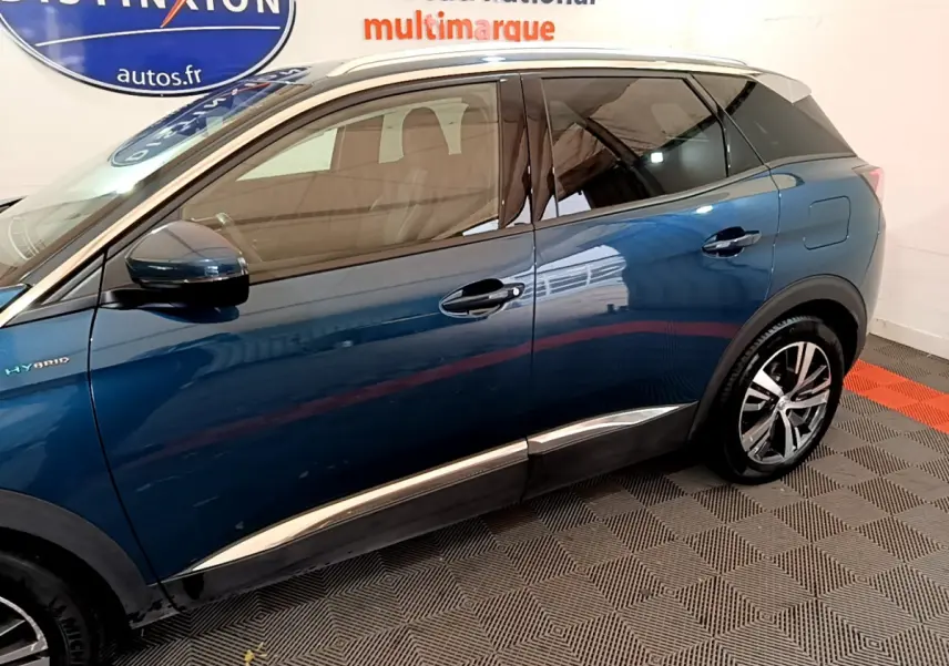 Profil côté gauche du Peugeot 3008 hybride rechargeable bleu avec jantes alliage et vitres teintées en intérieur showroom.