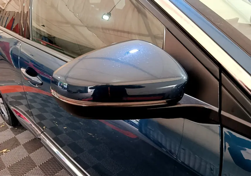 Rétroviseur côté gauche bleu métallisé du Peugeot 3008 hybride 2021, avec poignée de porte et vitre partiellement visibles.