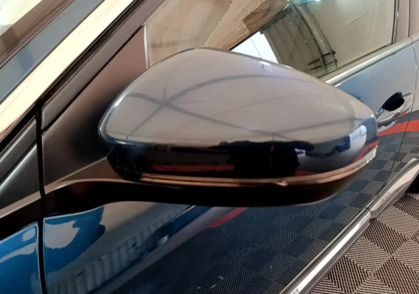 Rétroviseur latéral droit bleu brillant du Peugeot 3008 hybride rechargeable, avec carrosserie et poignée de porte visibles.