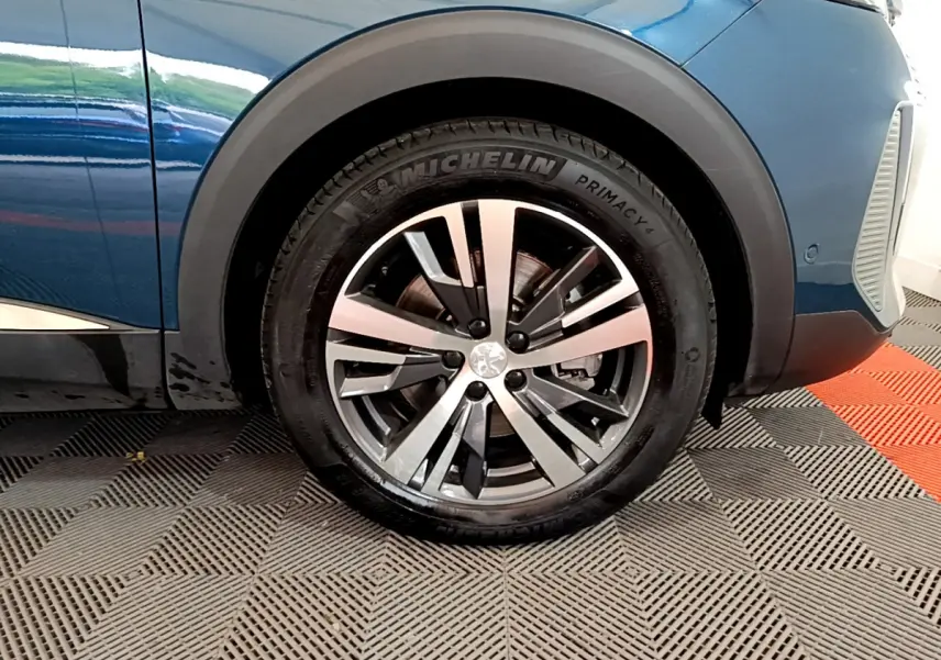 Gros plan sur la roue avant gauche du Peugeot 3008 bleu avec jante alliage et pneu Michelin Primacy.