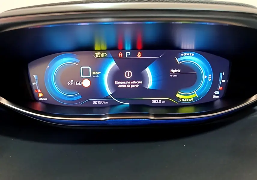 Tableau de bord numérique bleu du Peugeot 3008 hybride, affichant vitesse, autonomie et mode de charge.