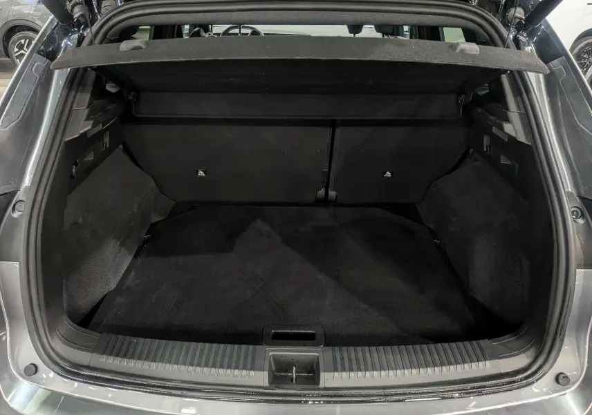 Coffre ouvert d'un Renault Austral gris schiste, vue arrière montrant l'espace de chargement noir et les finitions intérieures.