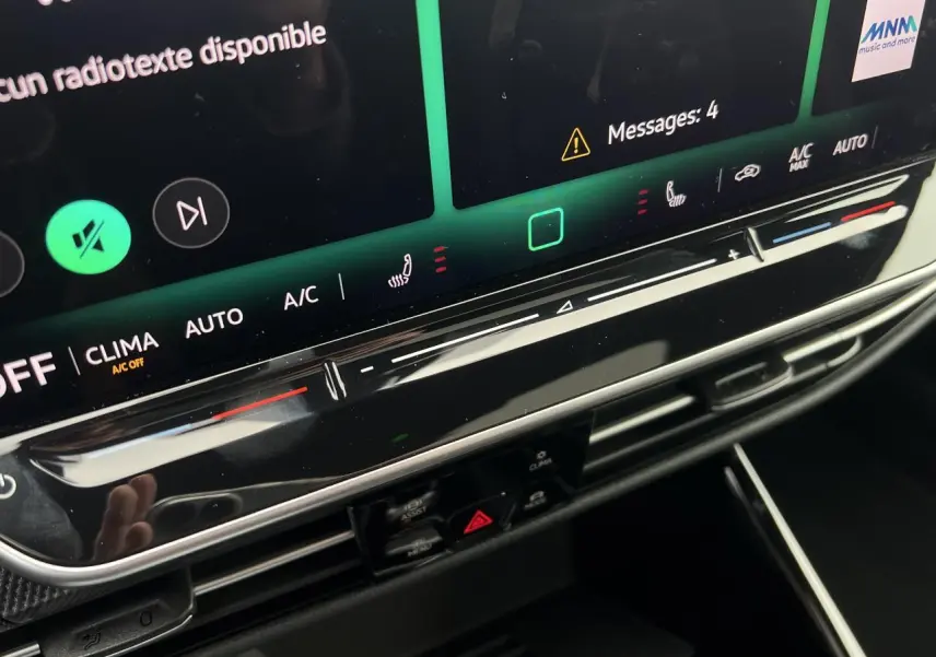 Gros plan sur la console centrale tactile de la Volkswagen Golf VIII noire, avec commandes climatisation et affichage digital.