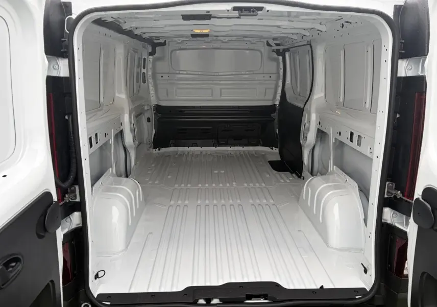 Vue intérieure arrière du Renault Trafic Fourgon blanc glacier, montrant l'espace de chargement vide et tôlé.