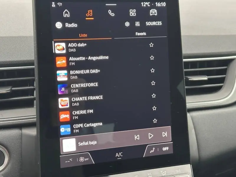 Écran tactile central du tableau de bord du Renault Captur 2025 affichant les stations radio DAB et FM.