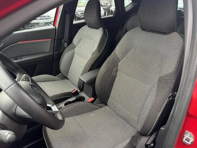 Vue intérieure côté conducteur du Renault Captur 2025 Rouge Flamme/Noir Etoilé, sièges tissu gris avec surpiqûres contrastées.