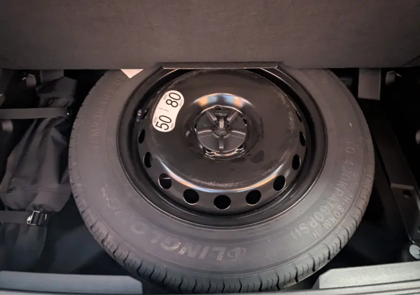 Gros plan sur la roue de secours temporaire noire dans le coffre du Renault Austral gris schiste 2025.