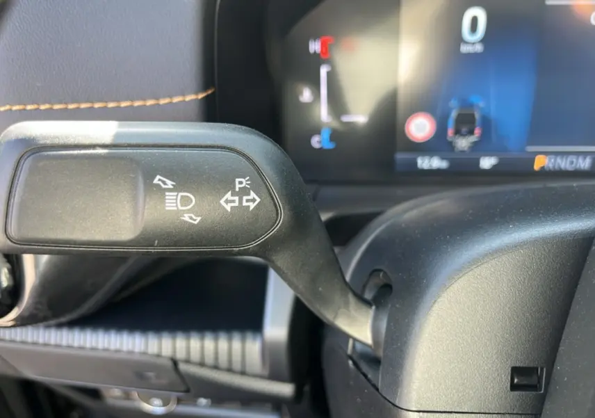 Gros plan sur la manette de clignotants noire avec coutures marron du tableau de bord du Ford Ranger gris carbone 2025.