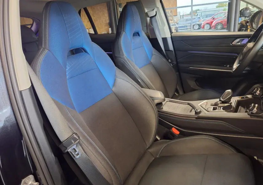 Intérieur du Lynk & Co 01 2023 vu côté gauche, sièges tissu noir et bleu avec console centrale moderne.