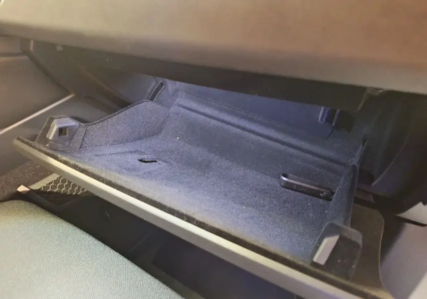 Vue rapprochée de la boîte à gants ouverte du Lynk & Co 01 hybride rechargeable, intérieur noir avec tissu bleu.