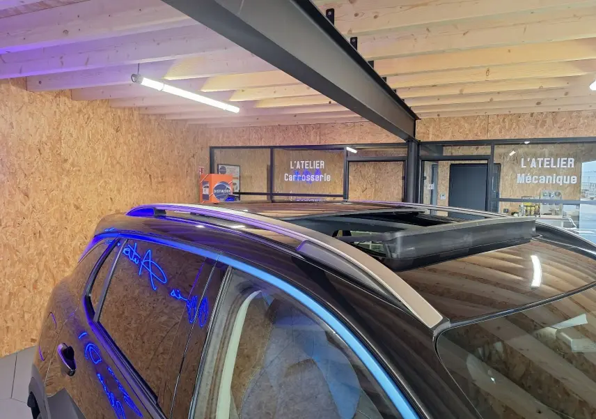 Vue rapprochée du toit ouvrant et des barres de toit argentées sur le côté gauche d'un LYNK & CO 01 noir.