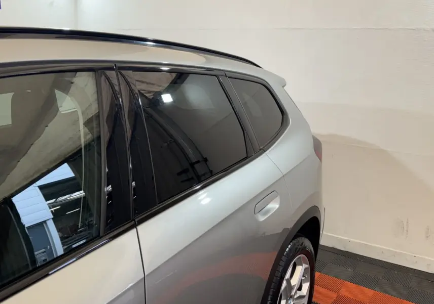 Vue côté arrière droit du BMW X1 sDrive20i gris foncé, mettant en valeur la porte arrière et la jante alliage.