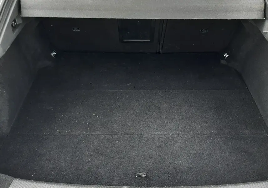 Vue depuis l'arrière du coffre noir vide de la Peugeot 508 blanche, avec banquette arrière et cache-bagages visibles.