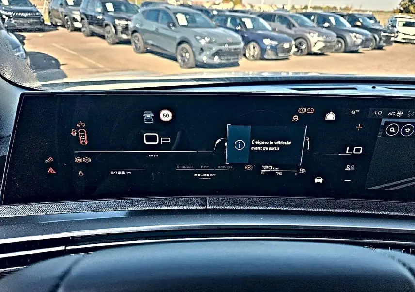 Vue intérieure du tableau de bord numérique du Peugeot 5008 Hybrid 145 allure e-dcs6, affichage multifonction et alertes visibles.