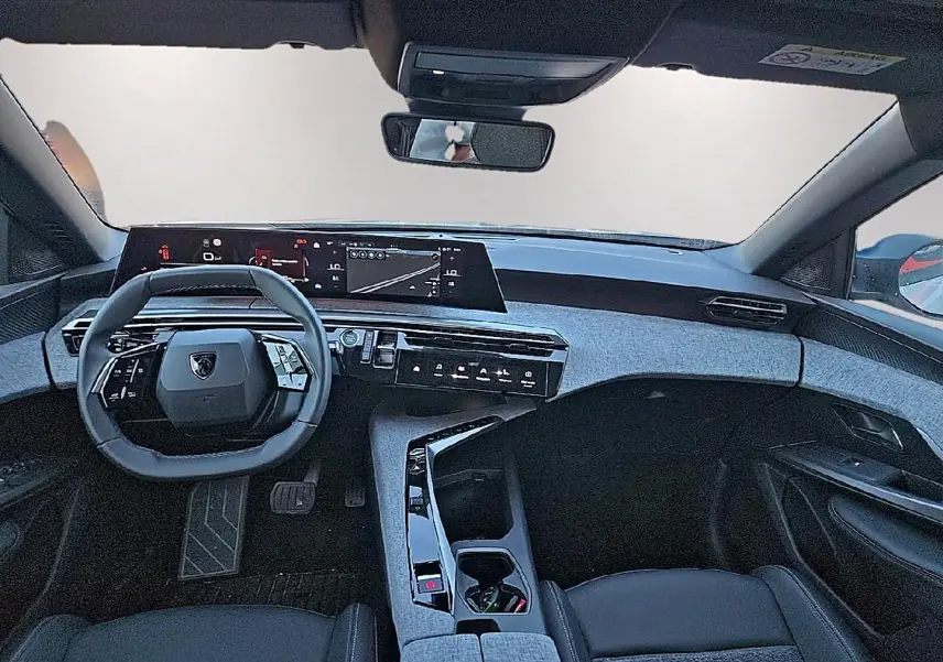 Vue intérieure avant du Peugeot 5008 Hybrid blanc, avec tableau de bord numérique et volant cuir multifonction.