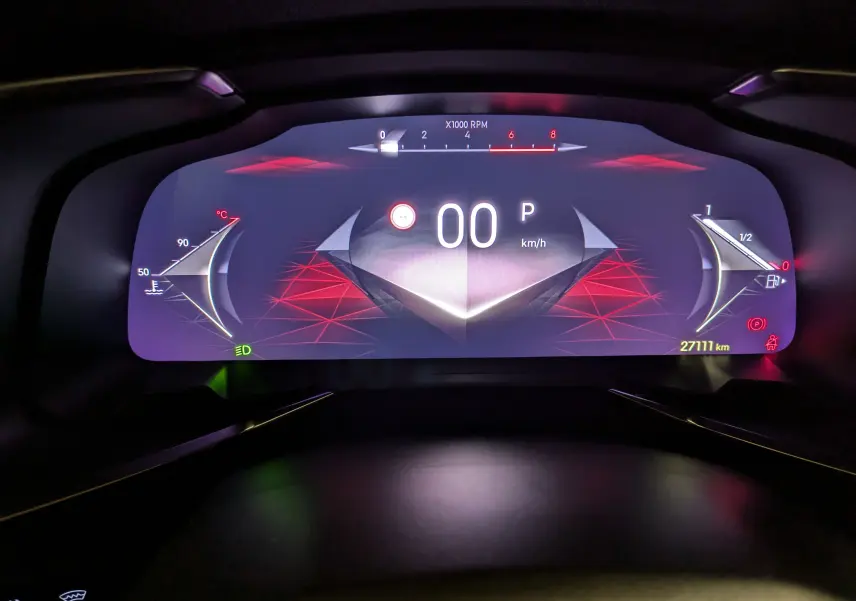 Affichage numérique du tableau de bord du DS7 BlueHDi 130 en mode parking, avec graphismes rouges et compteurs stylisés.