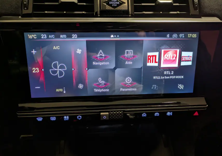 Écran tactile central du DS7 2023 affichant la climatisation, navigation et radio RTL2 dans un intérieur noir élégant.