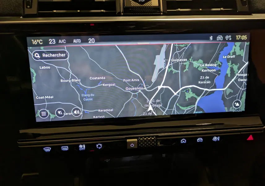 Écran tactile central du DS7 2023 affichant la navigation GPS avec commandes climatisation et bouton start/stop visibles.
