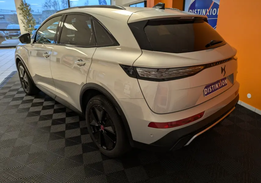 Vue 3/4 arrière droite du DS7 BlueHDi 130 en Chrystal Pearl, avec jantes alliage noires et vitres teintées.