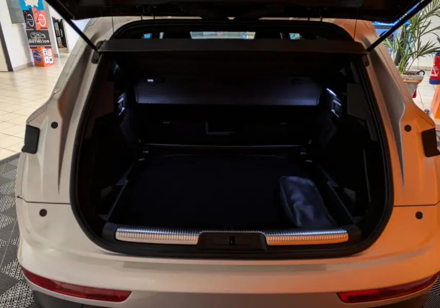 Coffre ouvert du DS7 BlueHDi 130 blanc Chrystal Pearl, vue arrière avec intérieur spacieux et éclairage LED.