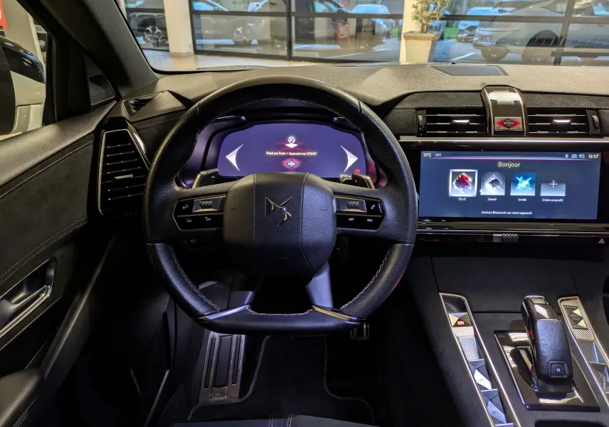 Vue intérieure centrée sur le volant DS et le tableau de bord numérique d'une DS7 2023 avec finition Alcantara noir.