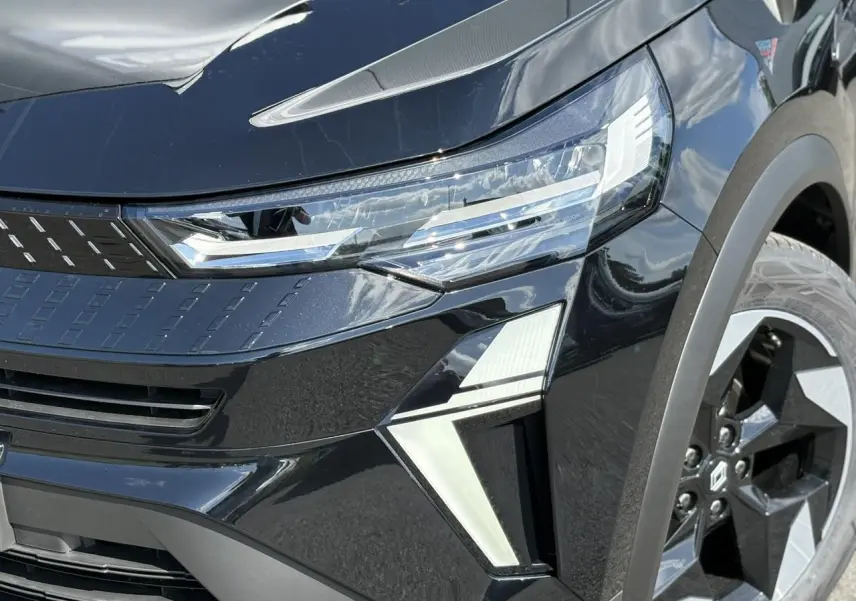 Gros plan sur l'avant droit noir étoilé du Renault Captur 2025 avec ses phares LED et jantes aluminium distinctives.