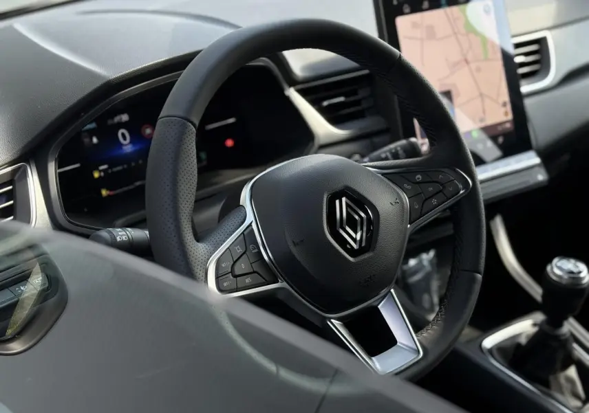 Volant en cuir noir avec commandes intégrées et écran tactile vertical du tableau de bord du Renault Captur 2025.