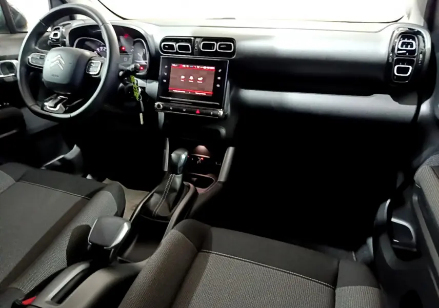 Vue intérieure avant du Citroën C3 Aircross 2019, tableau de bord noir avec écran tactile central et volant multifonctions.