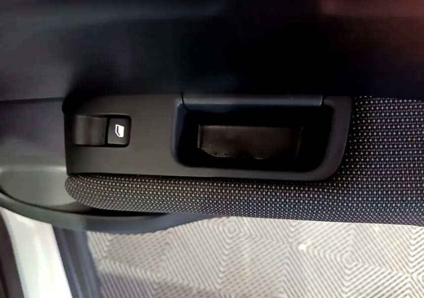 Gros plan sur la poignée intérieure et commande de lève-vitre côté gauche du Citroën C3 Aircross blanc.