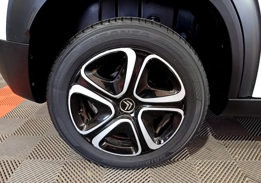 Gros plan sur la roue avant droite noire et argentée du Citroën C3 Aircross blanc de 2019.