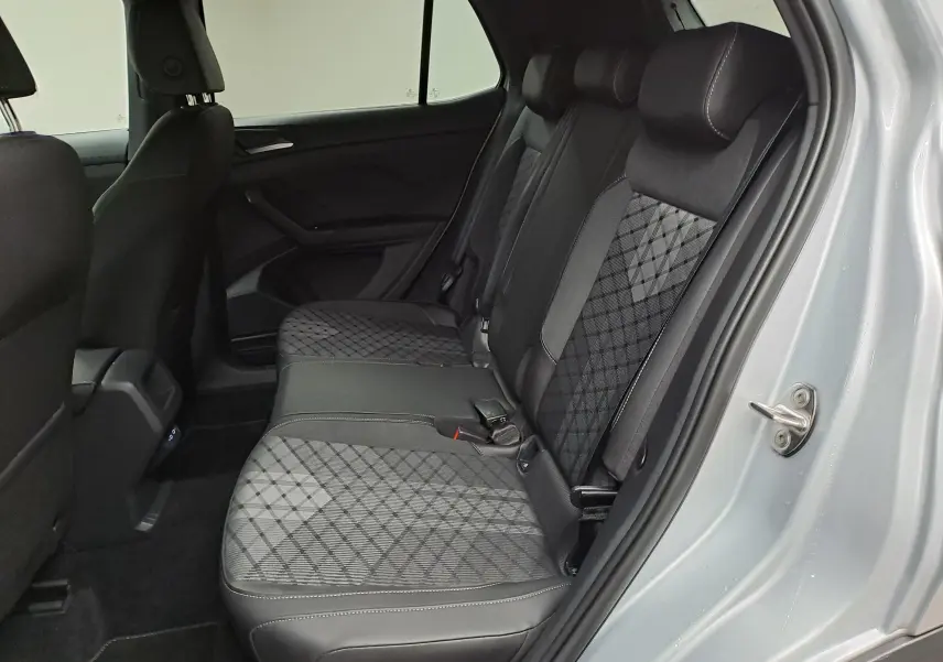 Vue intérieure côté droit des sièges arrière du Volkswagen T-Cross 2025 en Reflet d'argent, avec sellerie tissu et cuir à motif géométrique.