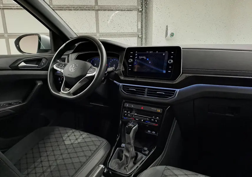 Vue intérieure côté conducteur du Volkswagen T-Cross 2025 R-Line Edition, mettant en valeur le volant multifonction et l'écran tactile central.