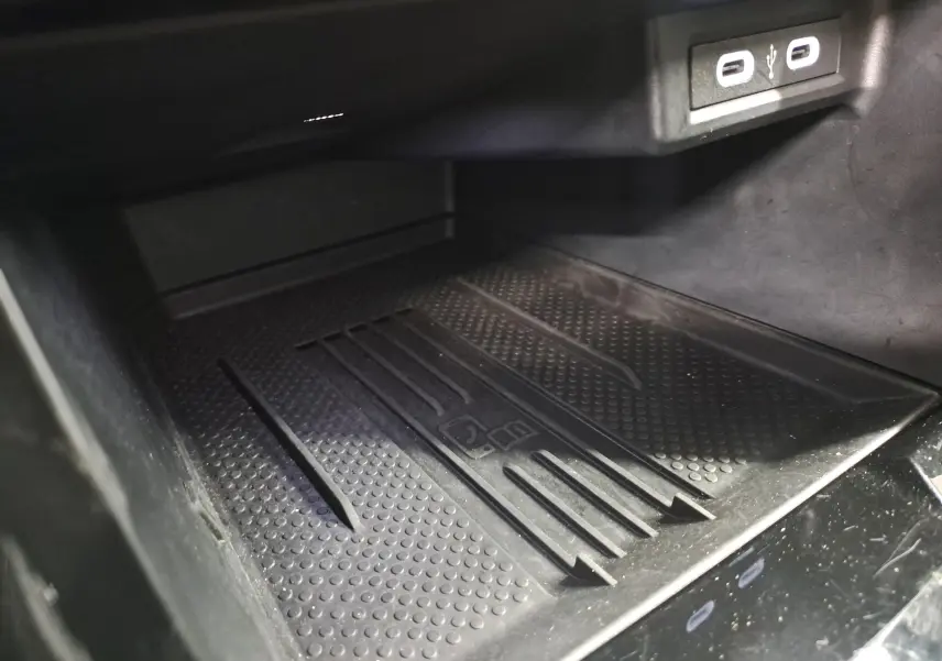 Gros plan sur le chargeur sans fil noir et les ports USB dans l'habitacle du Volkswagen T-Cross 2025 R-Line Edition.